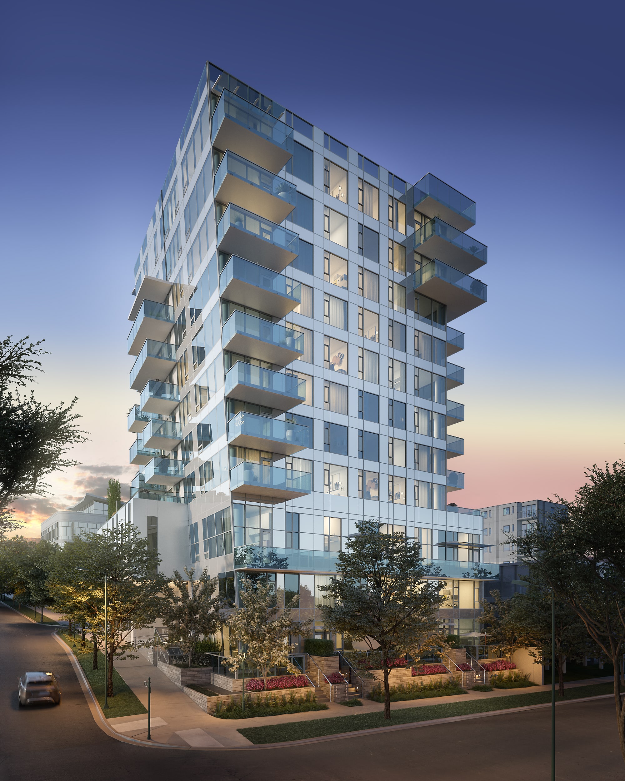 A modern, multi-story residential building with glass balconies and a landscaped foreground featuring trees and a paved walkway.