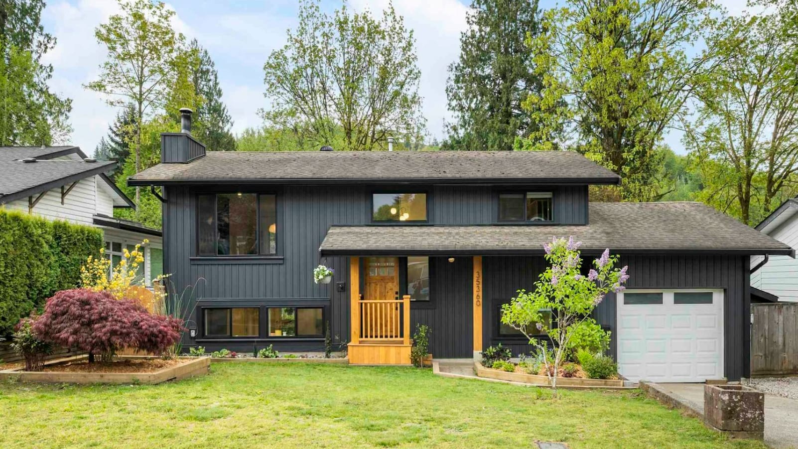 A dark grey house with a wooden porch in Abbotsford East.