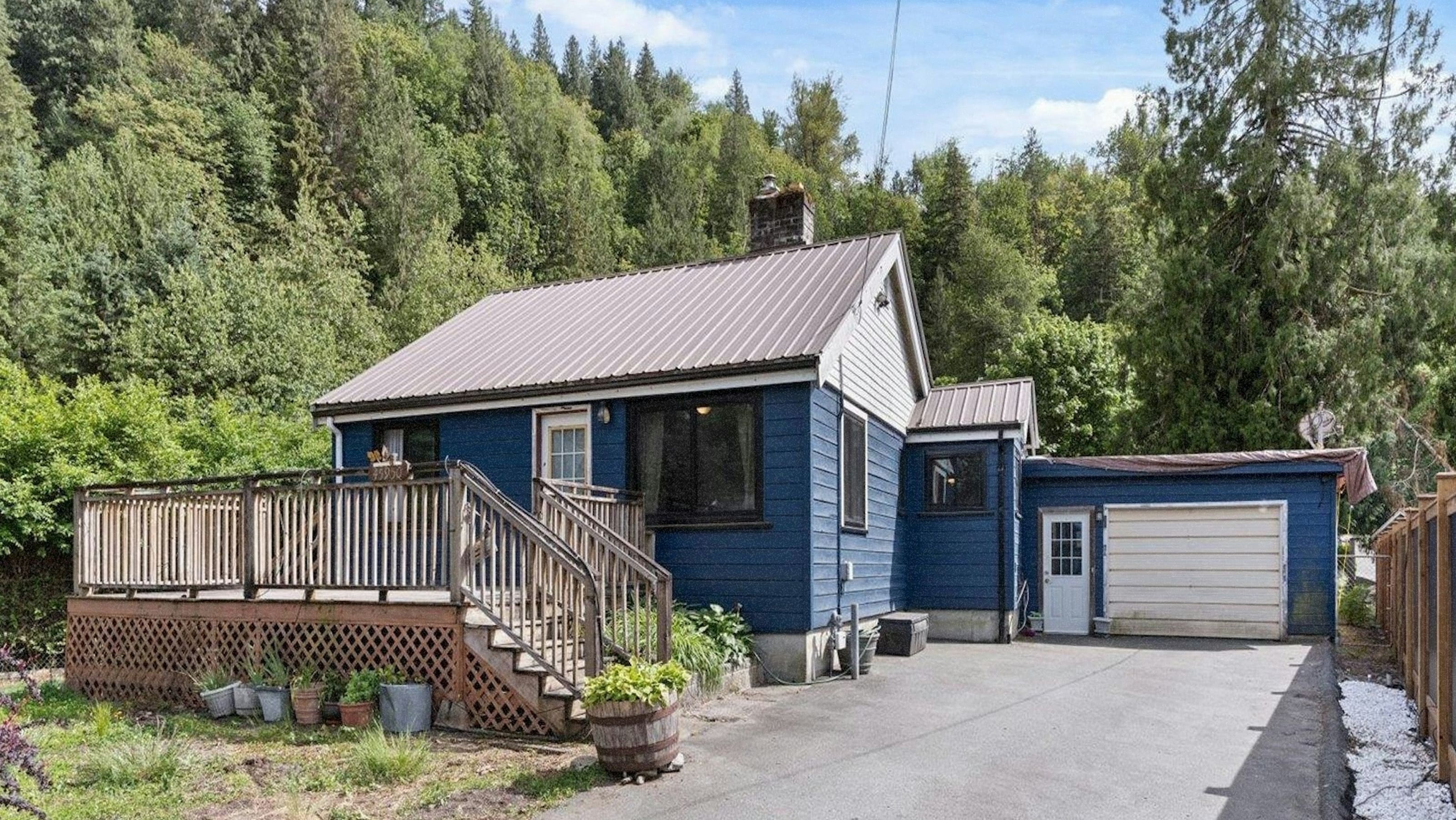 A blue house with a wooden deck in Cultus Lake.