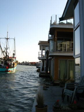 Float homes at Ladner Reach BC, fishboat passing.