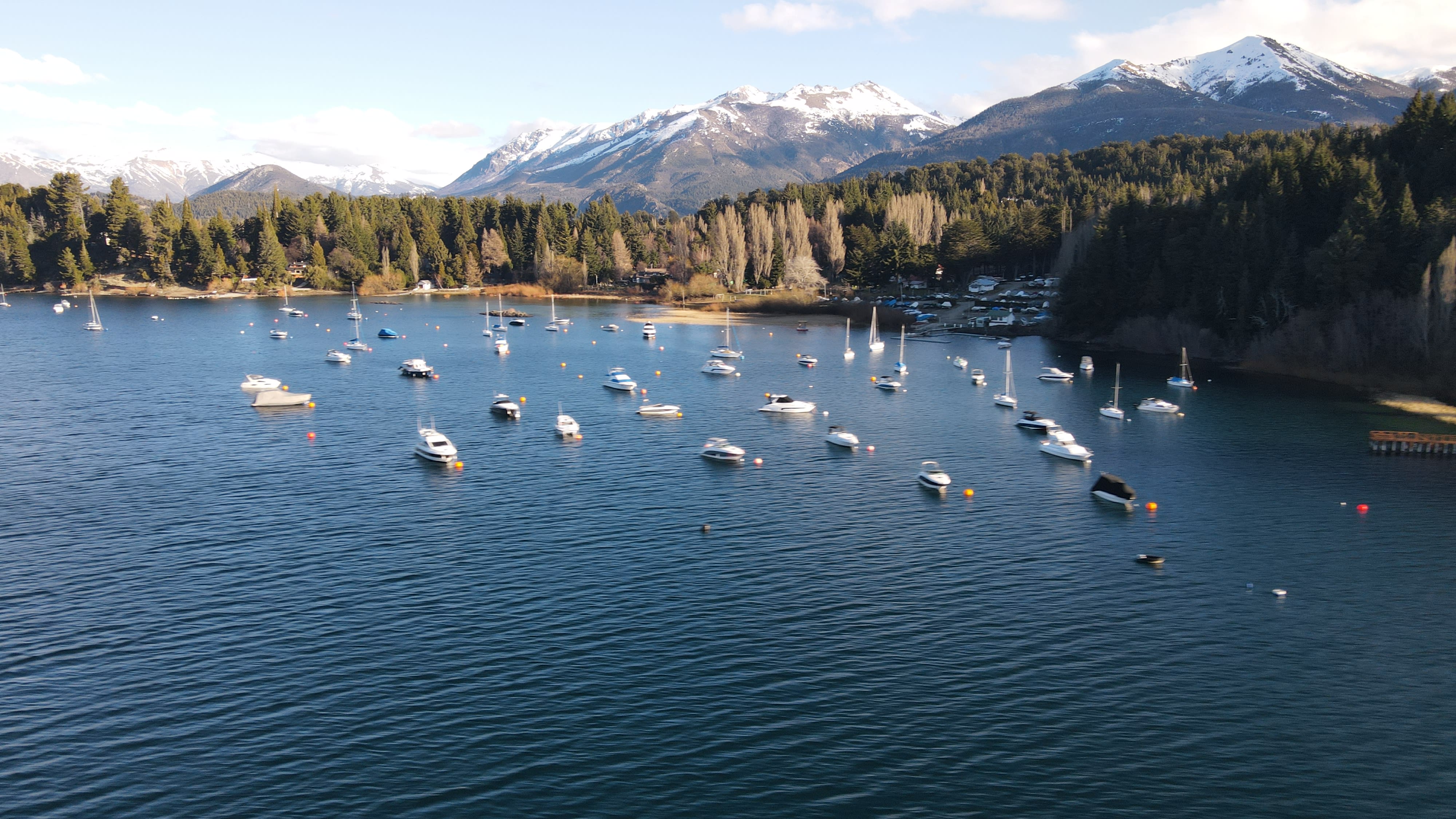 Bahía de Náutica Cirse con embarcaciones y montañas nevadas de fondo