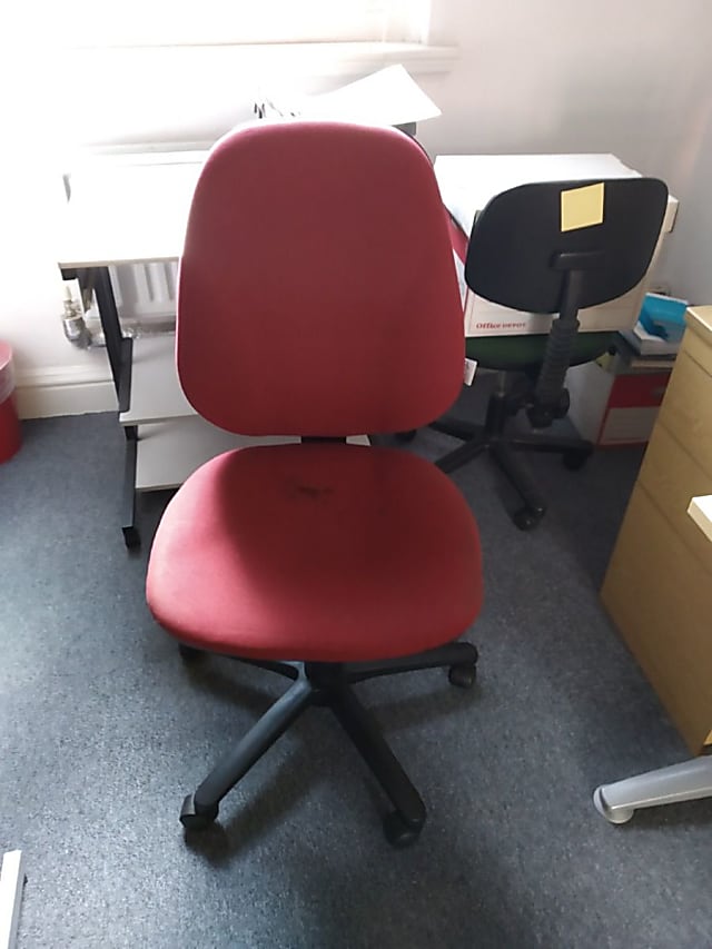 red rolling armless chair