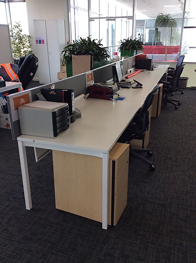 Bank of 4 white desks in a row