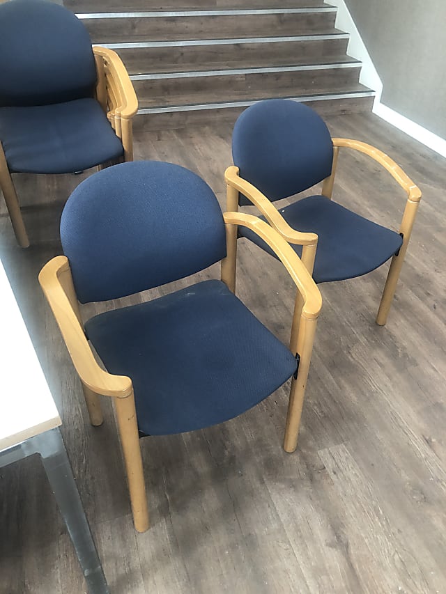 two brown wooden framed blue padded chairs