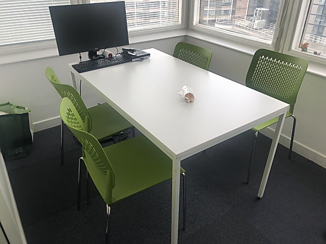 rectangular white wooden table with four chairs