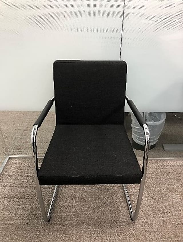 Black fabric chair with black leather arm and silver legs