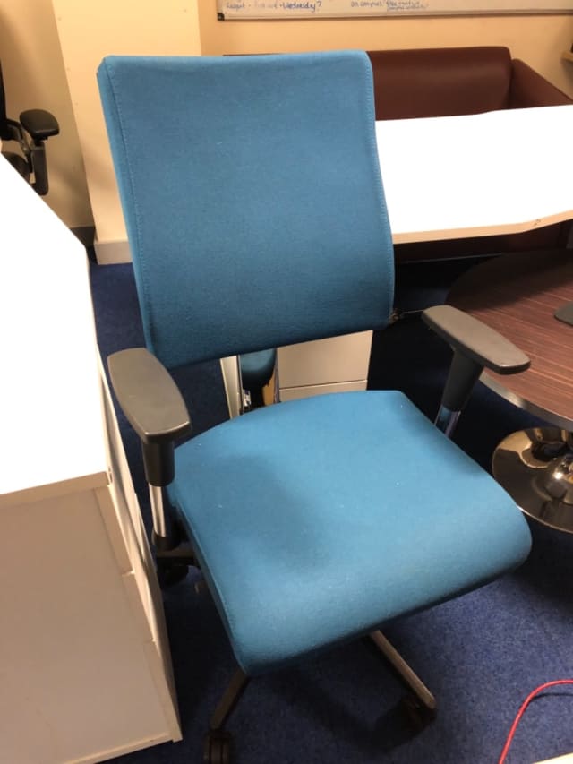 Blue padded operator chair on wheels