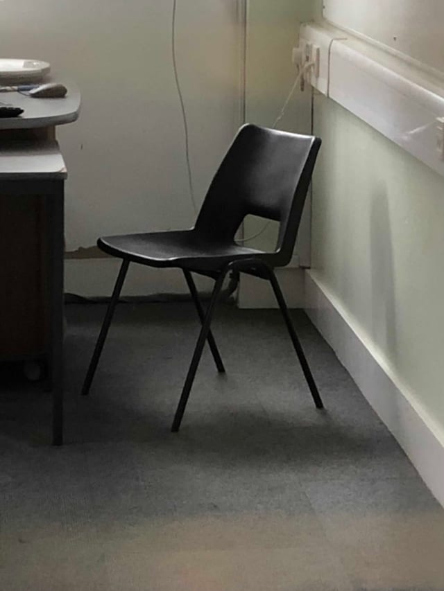 Black plastic waiting room chair with metal frame