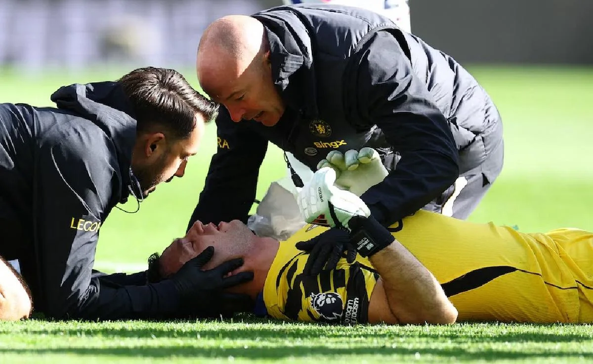 Emiliano 'Dibu' Martínez, el arquero argentino del Chelsea, atendido por médicos en el campo de juego.