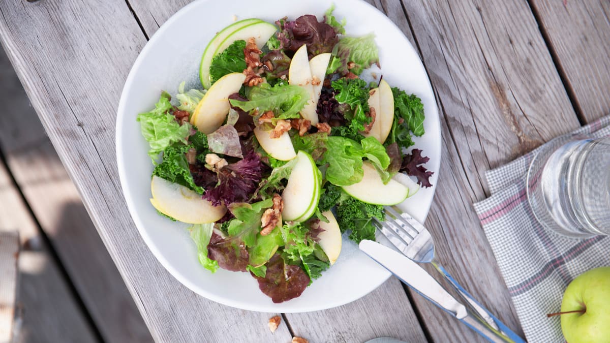 Žaliųjų lapinių kopūstų salotos su obuoliais, graikiniais riešutais ir obuolių padažu