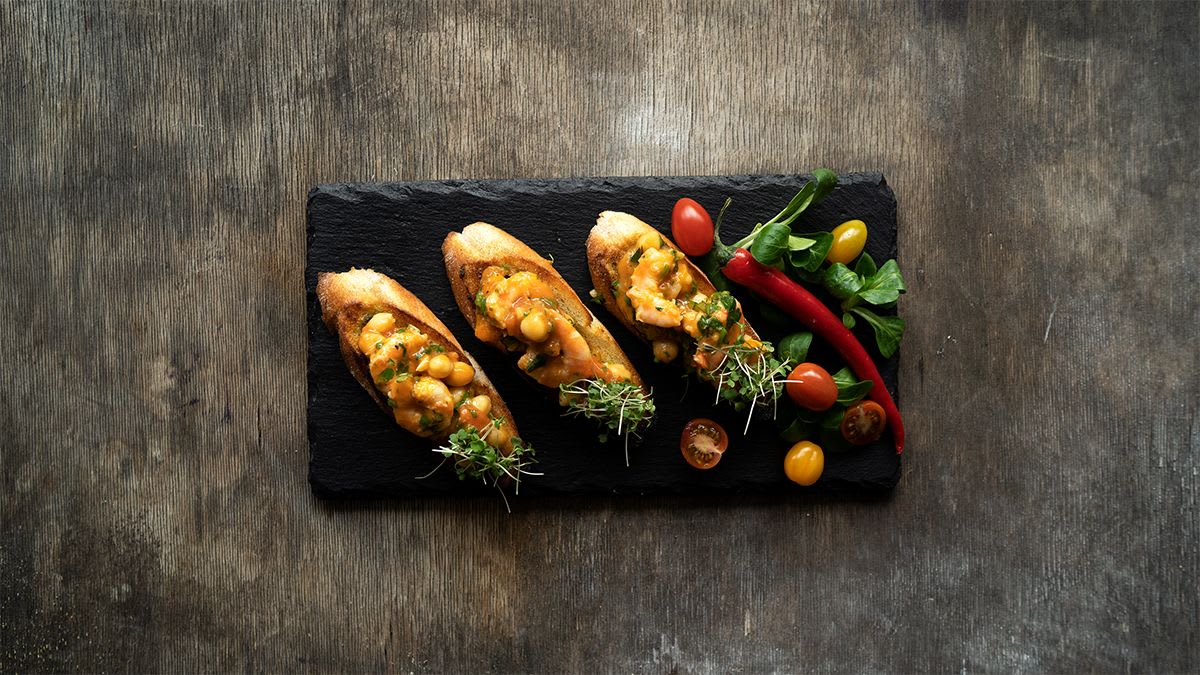 Brusketa ar tomātiem, garnelēm un turku zirņiem