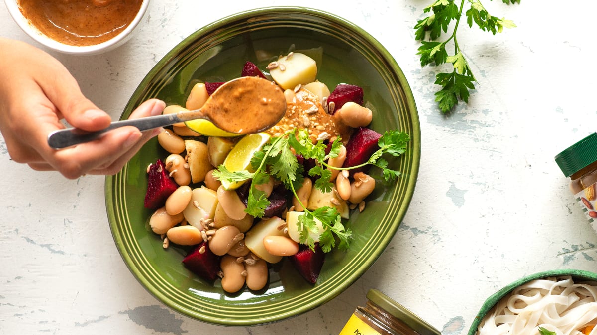 Salotos su burokėliais, baltosiomis pupelėmis ir riešutų sviesto padažu