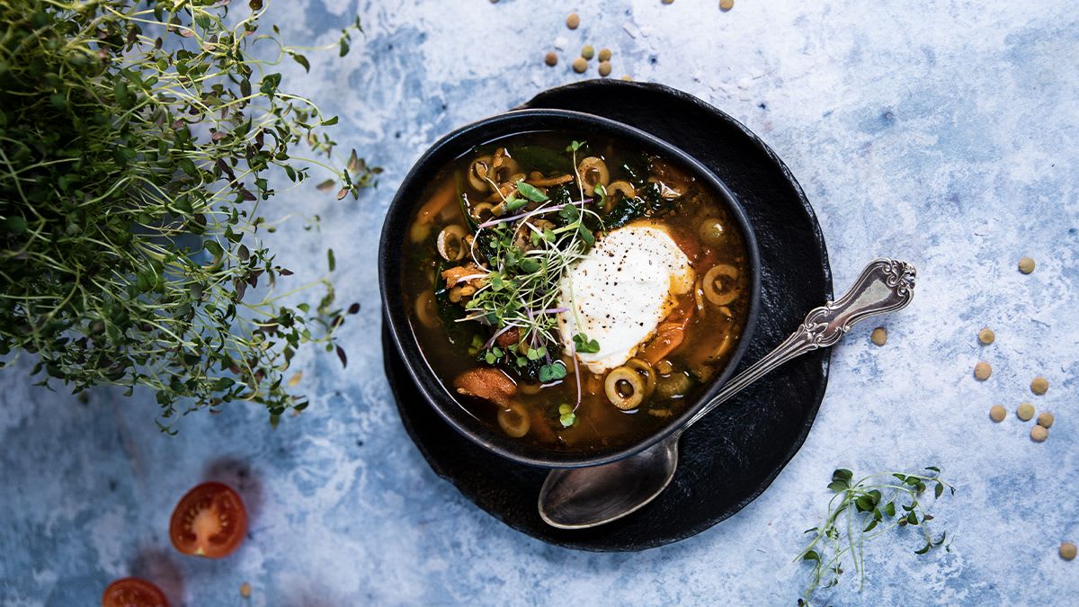 Kosutav rohelise läätse supp oliivide, köögiviljade ja ürtidega