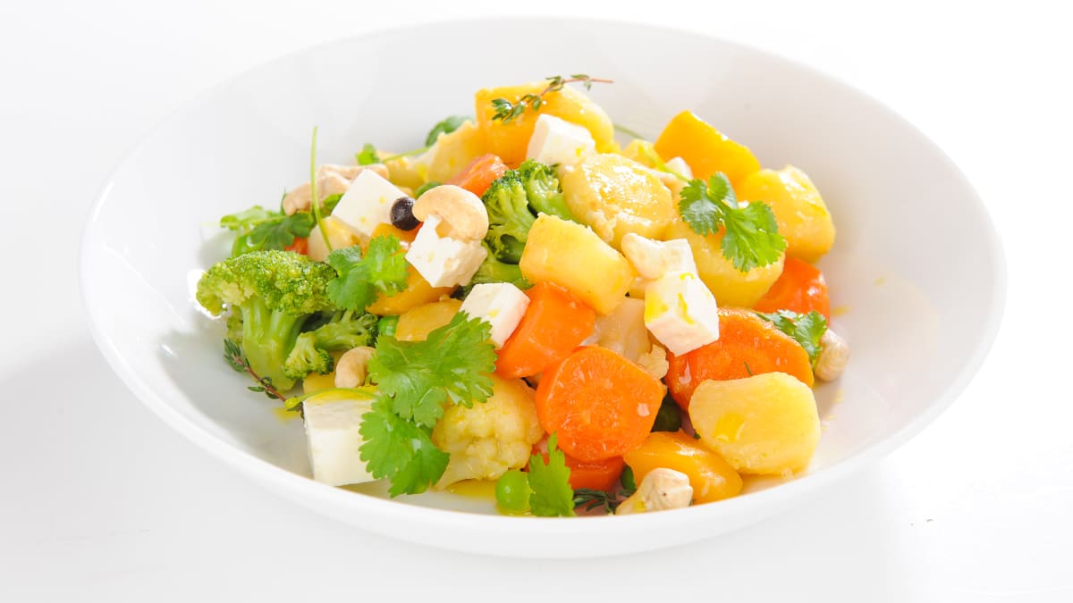 Dārzeņu sautējums ar garšaugiem, fetas sieru un Indijas riekstiem