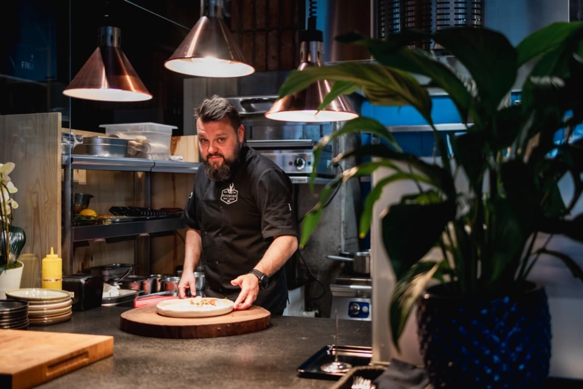 Chef Michał Rybak przygotowuje ciasto na pizzę w otwartej kuchni Riverside