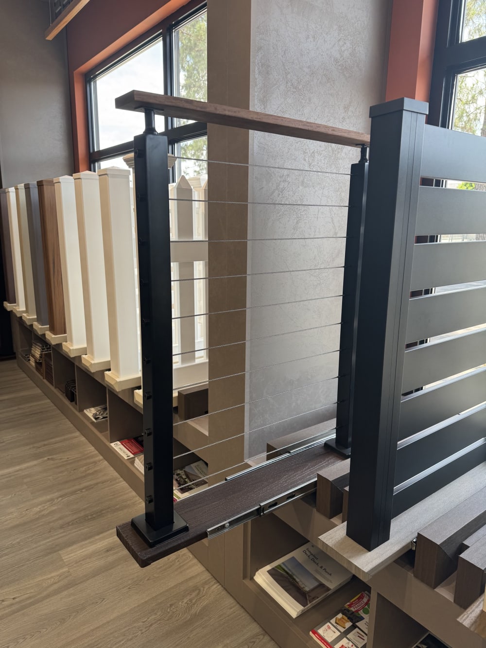 Cable railing with a wood top rail beside horizontal slat fence panels