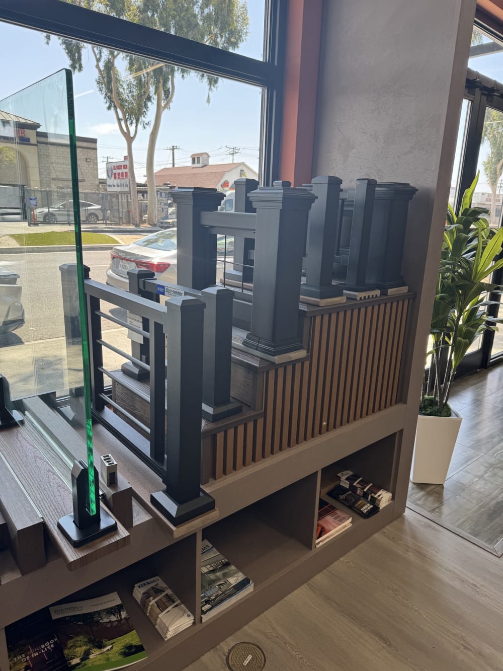 Glass railing panel and composite deck railing displays beside the showroom window