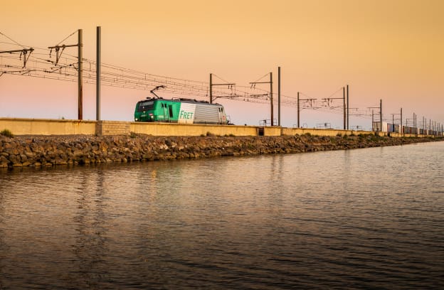 Train roulant sur des rails à côté d'un point d'eau