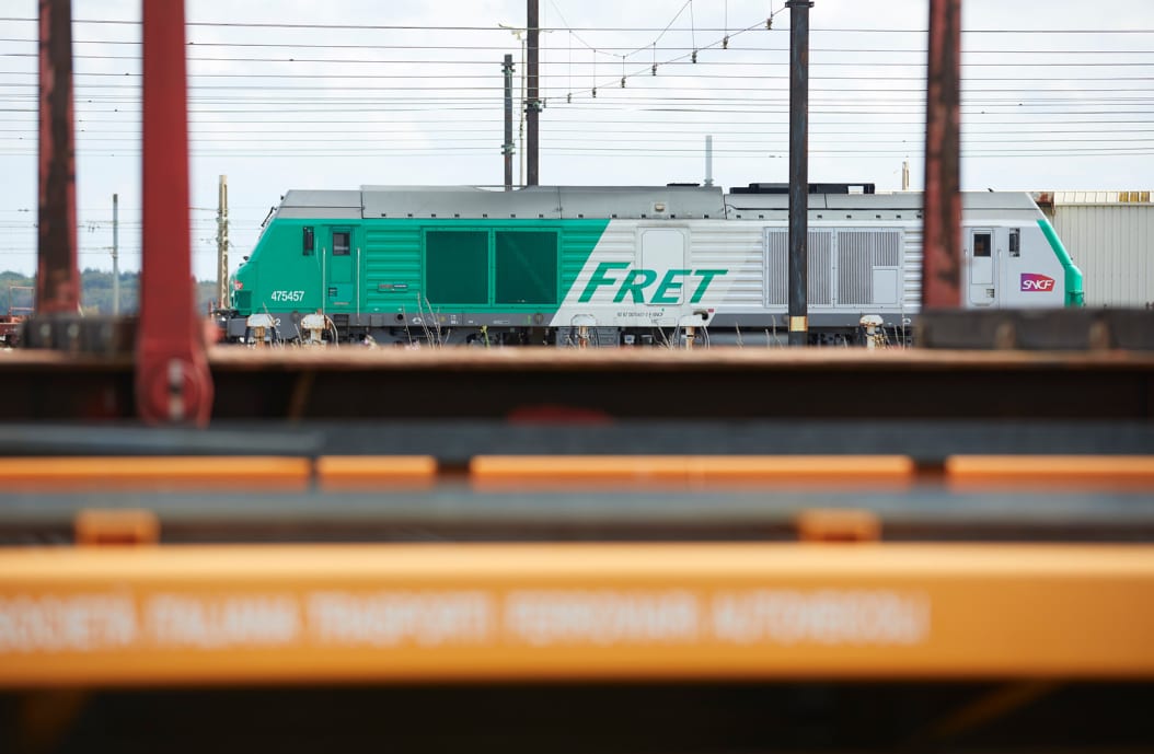 Train flou au premier plan laissant la vue sur un train Fret derrière