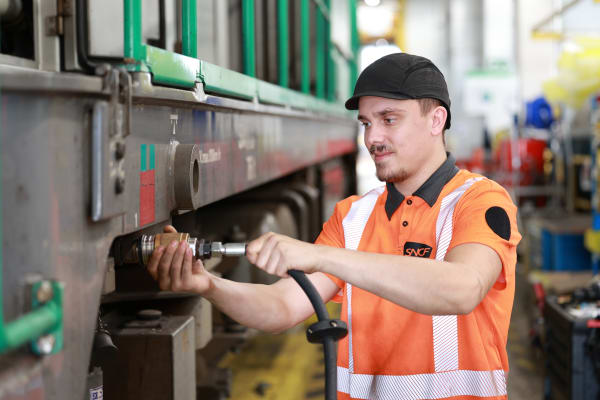 Photo d'un agent Technis opérant une manoeuvre de maintenance sur une locomotive