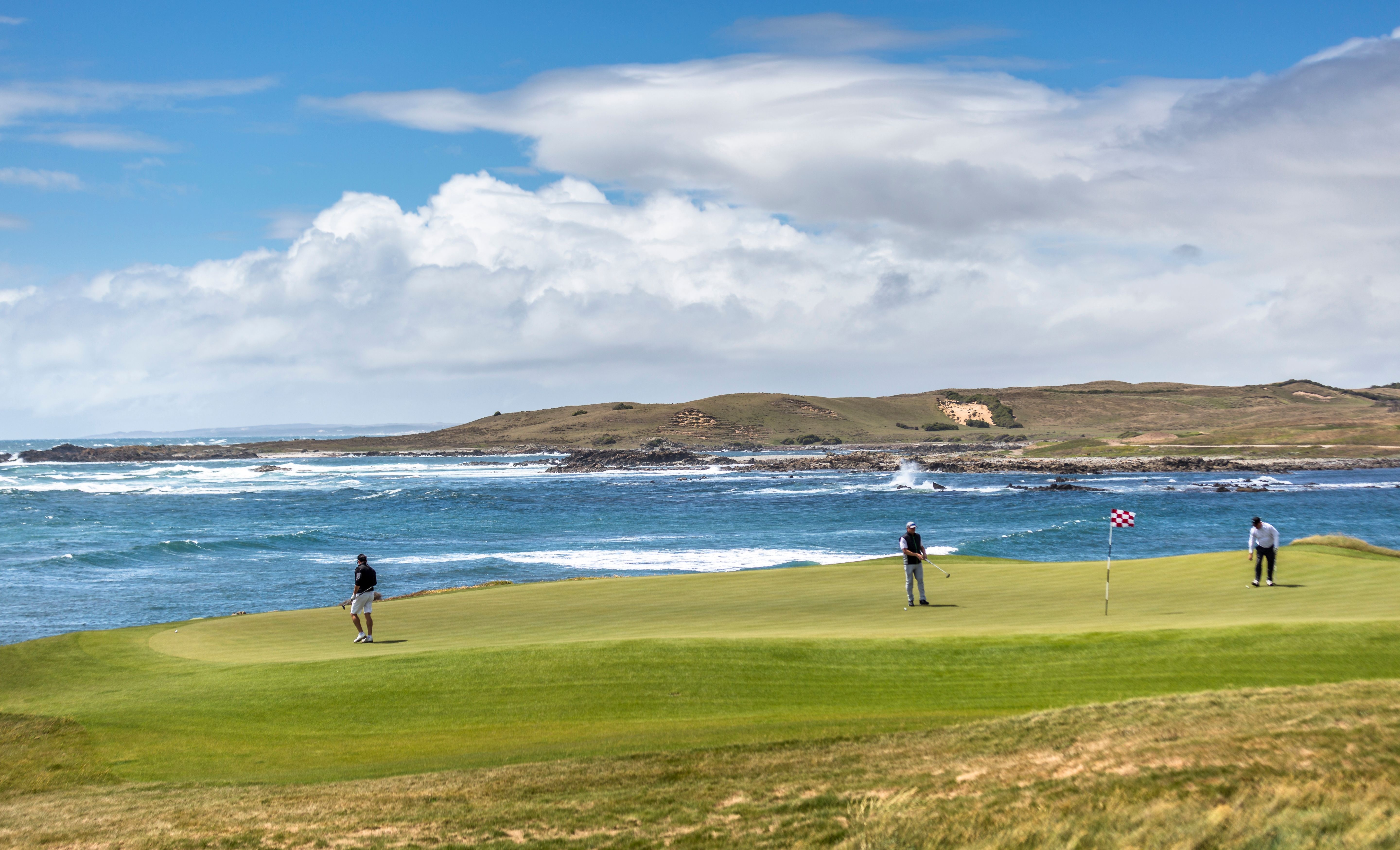 Golfers on a coastal King Island golf course beside Bass Strait
