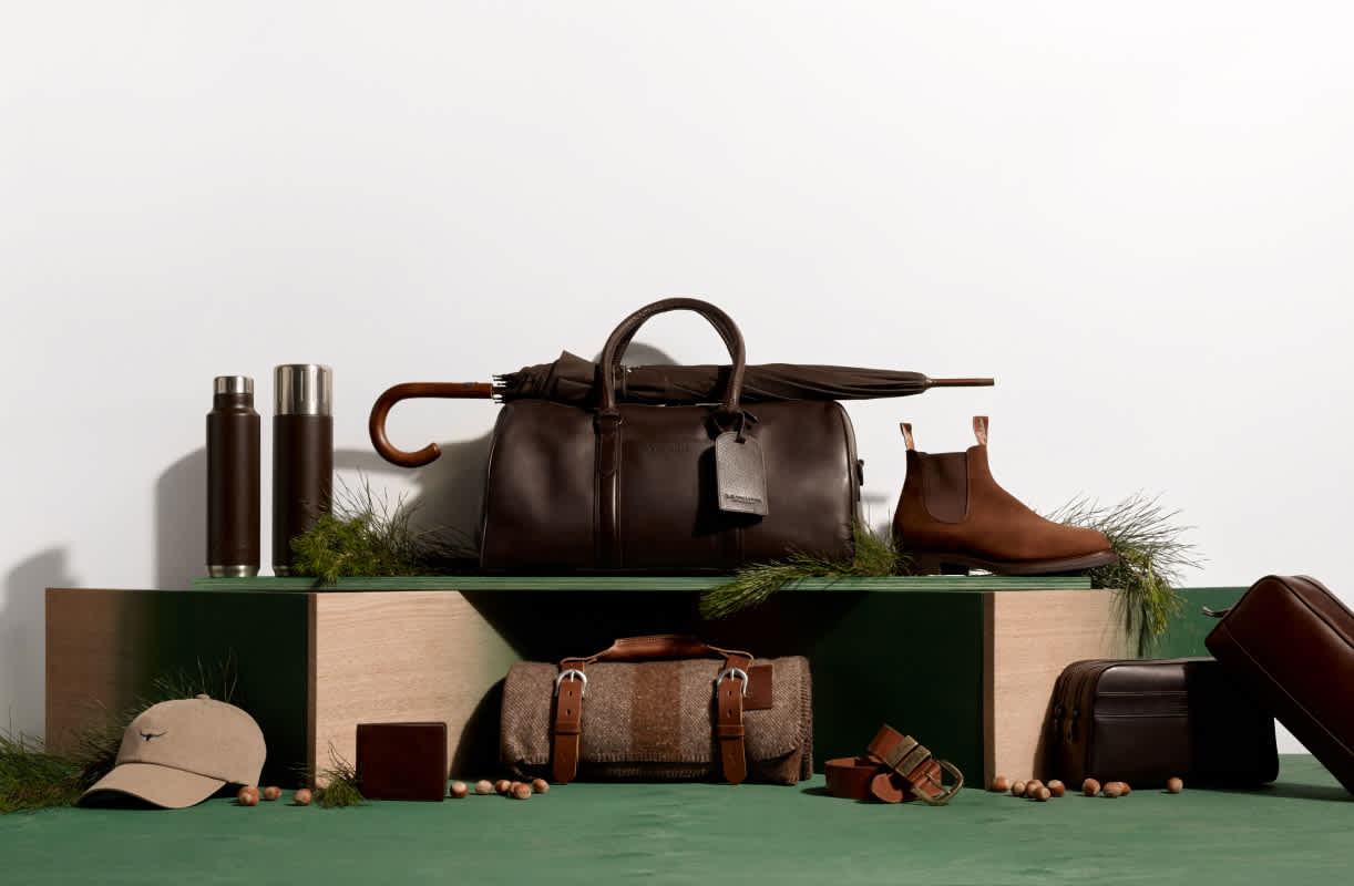 Man sitting on wooden stairs by hilly terrain, looking pensively