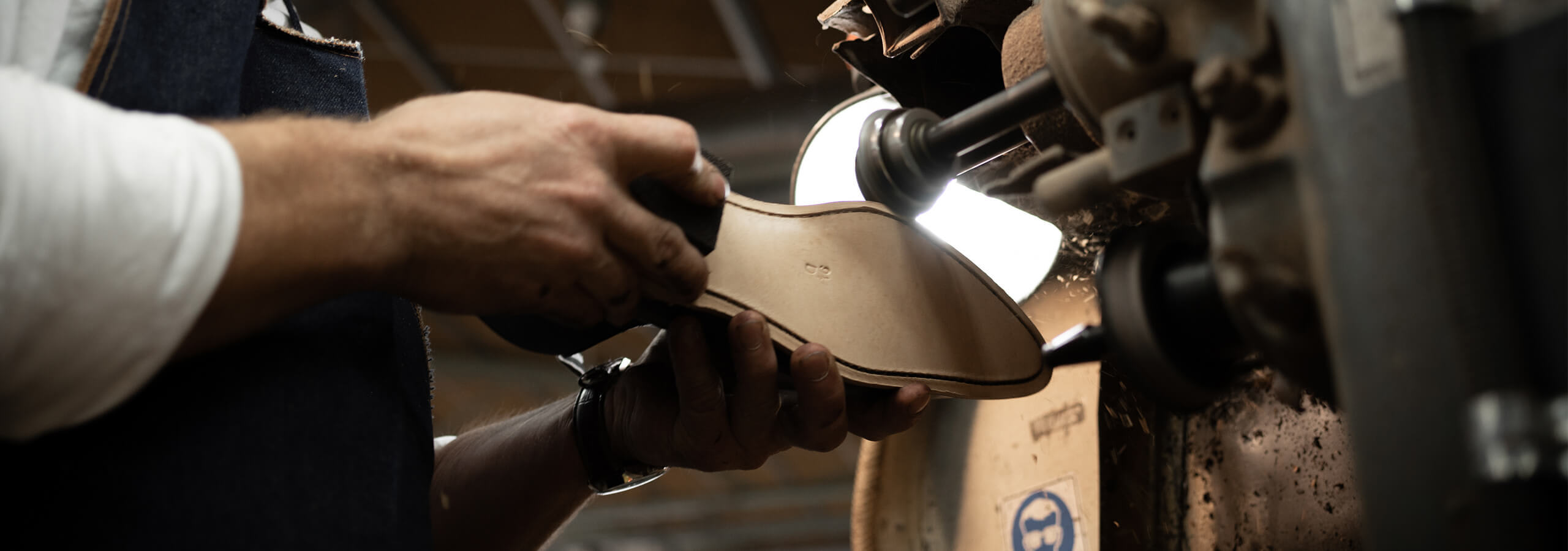 Craftsman holding a boot and working on it. 