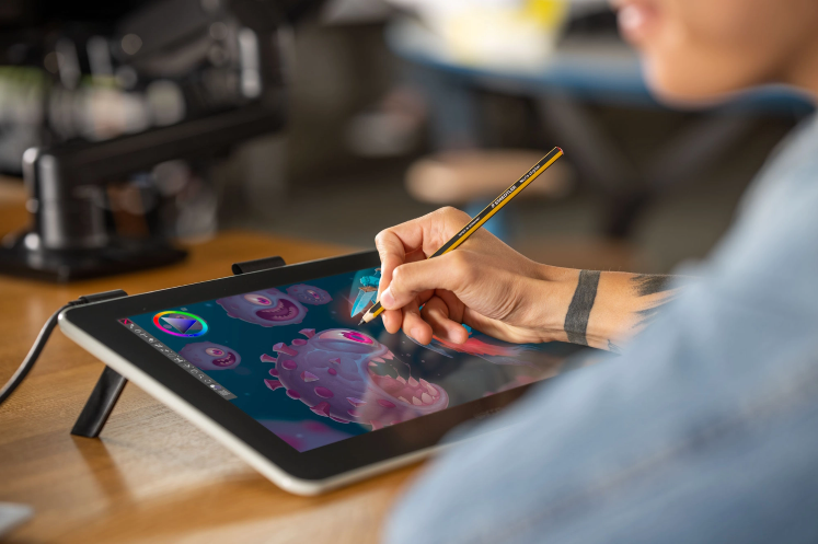 Person using a Wacom One to draw a purple virus animation