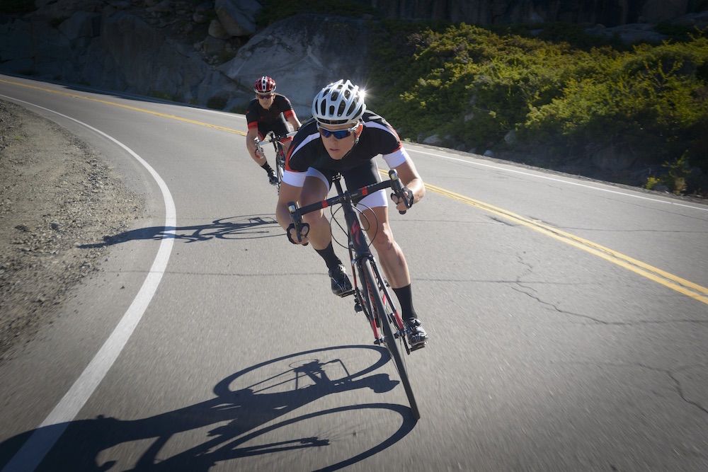 Two Specialized road riders coming through a curve