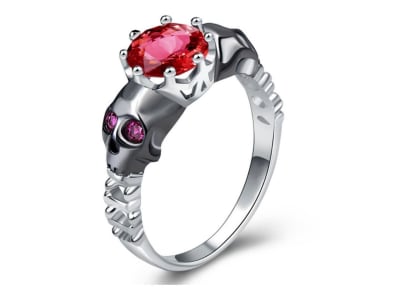 Anillo de mujer con brillante rojo central y en los laterales tiene carabelas co ...