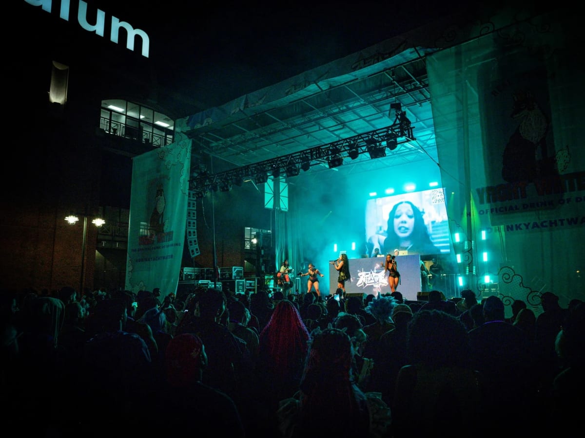 Atlanime Fest stage at night outside Center Parc Stadium, lit teal with an LED IMAG screen and a crowd in front