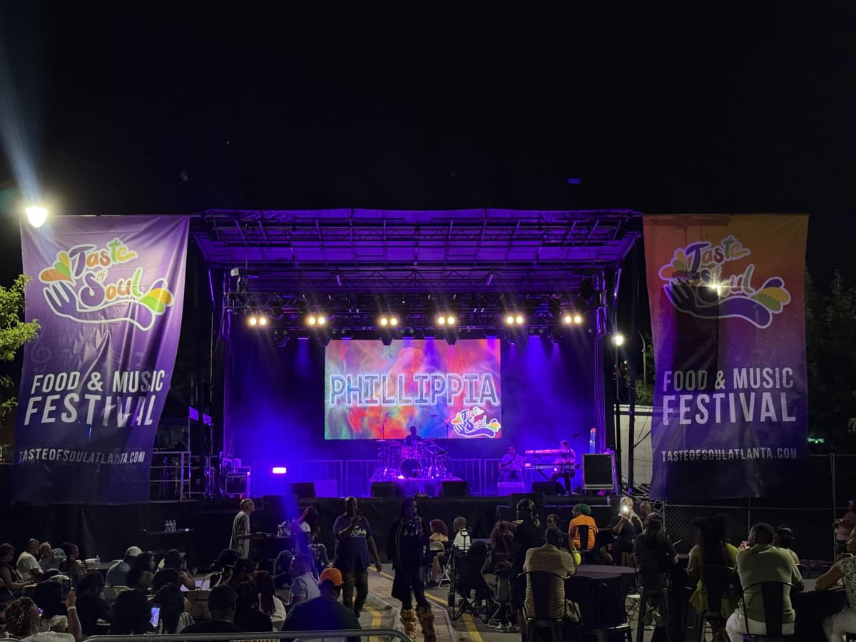 Taste of Soul Food and Music Festival stage at night with an artist graphic on the center LED screen and purple lighting
