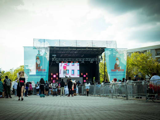 Atlanime Fest stage in daylight with sponsor banners on both sides and an LED screen at center