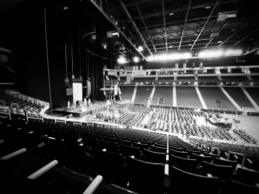 Black-and-white view of Gas South Arena from the upper seats, with the stage built on the arena floor