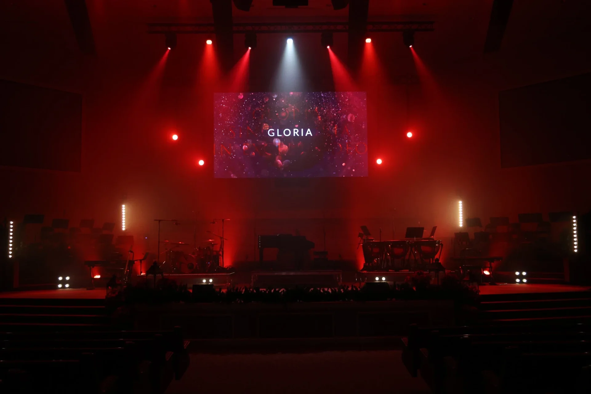 Church sanctuary with dramatic red lighting, LED screen, and vertical LED accent strips