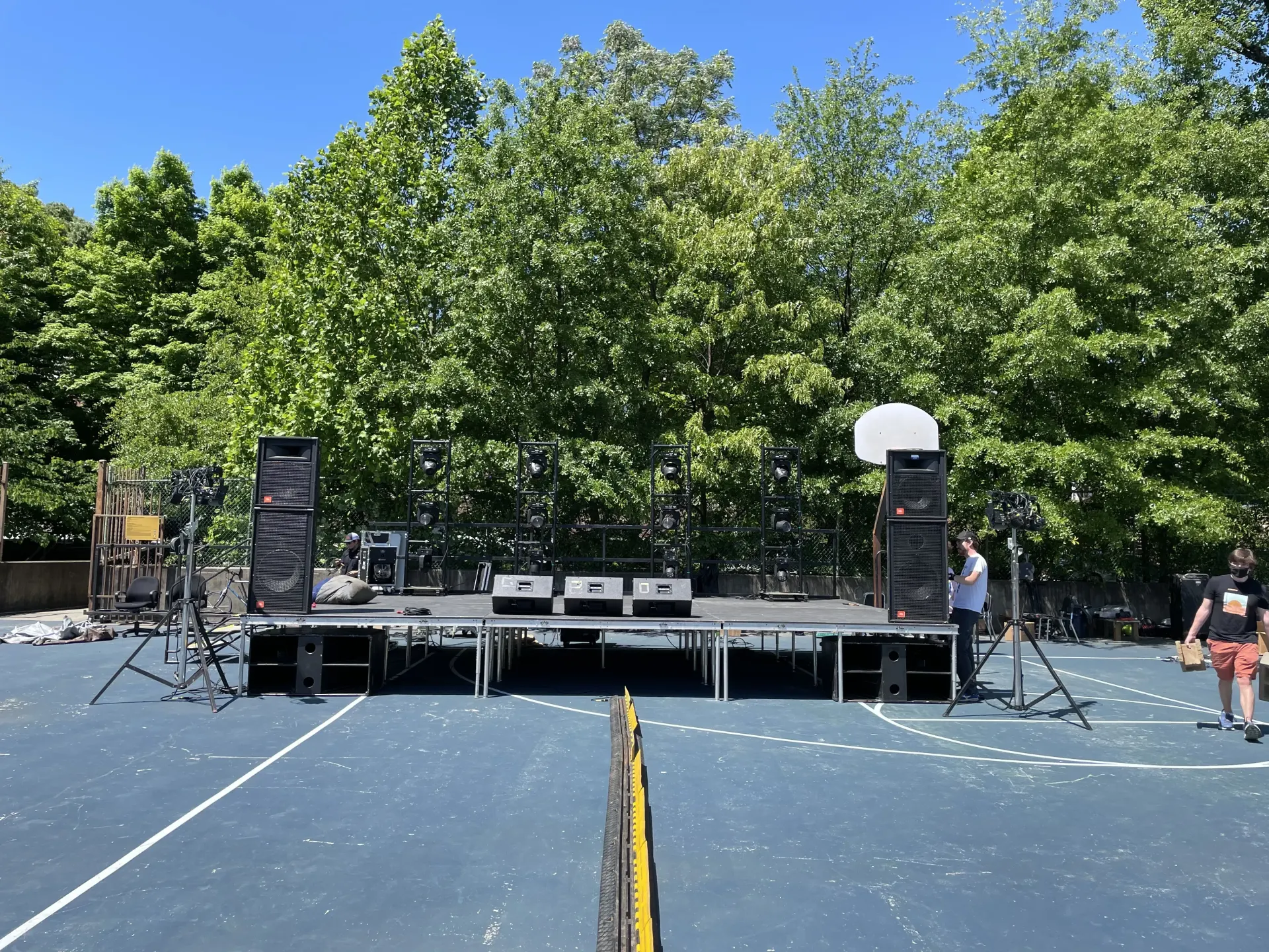 Outdoor graduation ceremony on multi-level modular deck staging with tiered platforms and steps