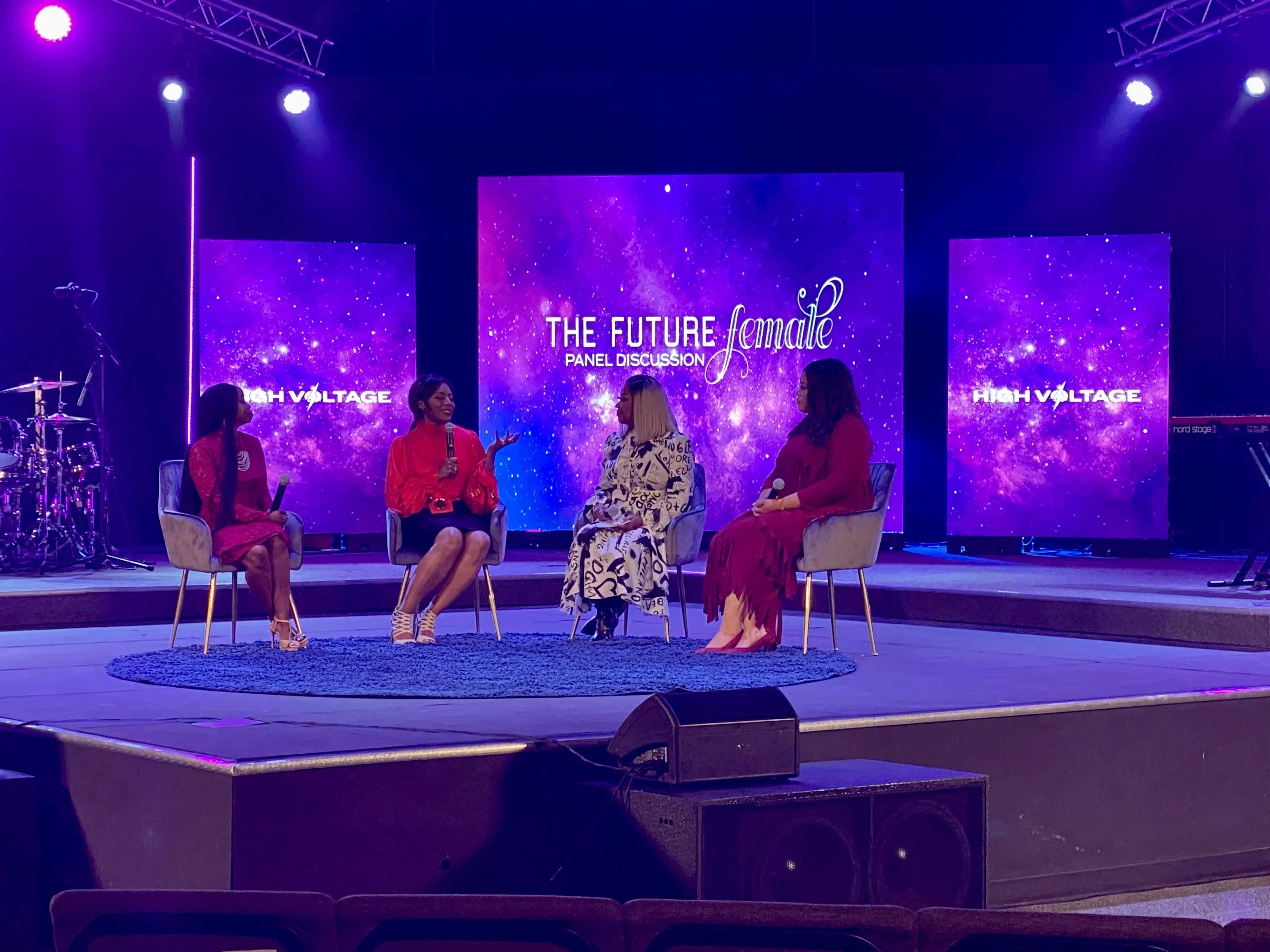 Women's ministry panel discussion on stage with multi-screen LED setup displaying galaxy-themed graphics