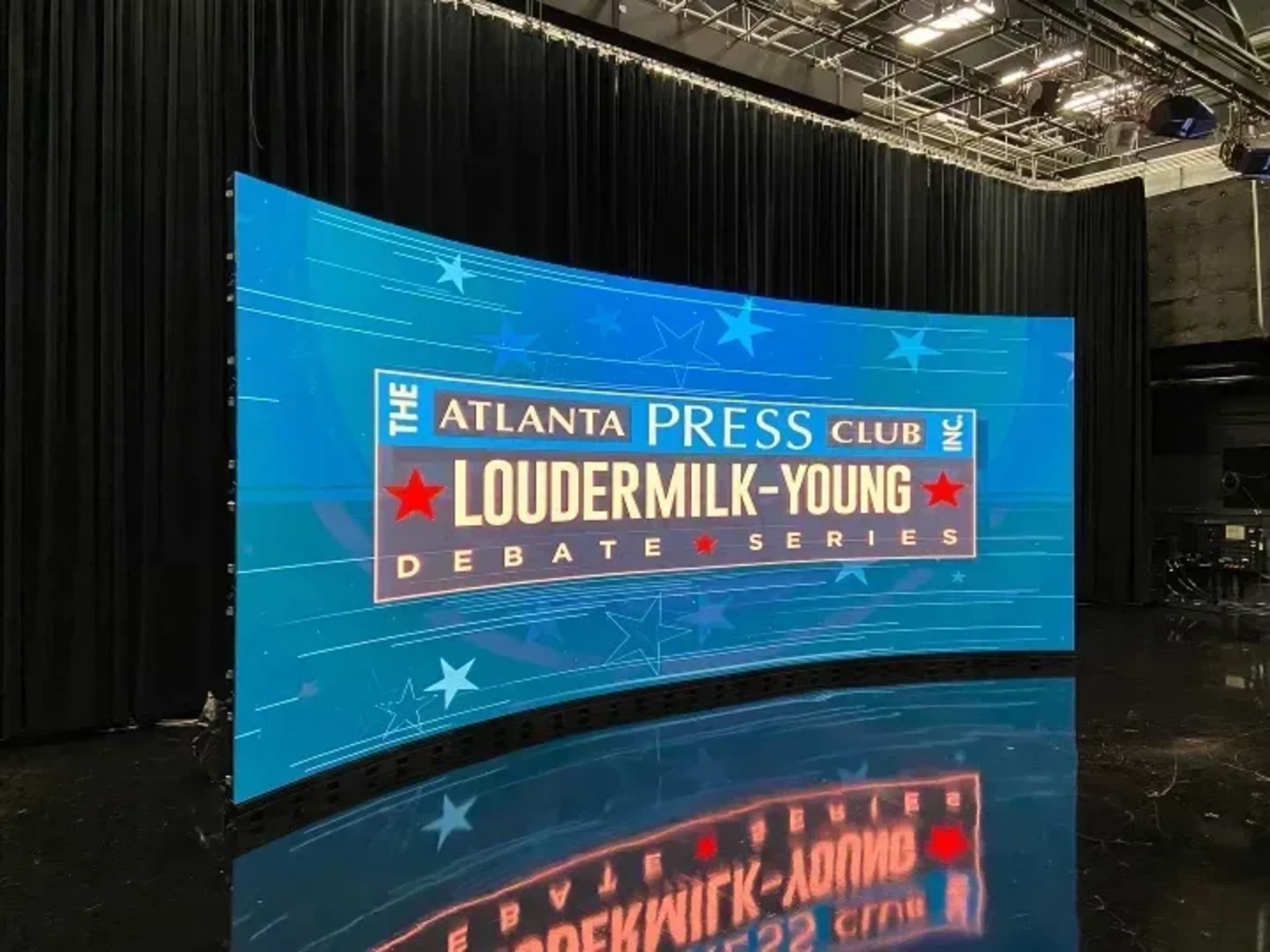 Press conference setup with podium, LED backdrop, and broadcast-ready lighting