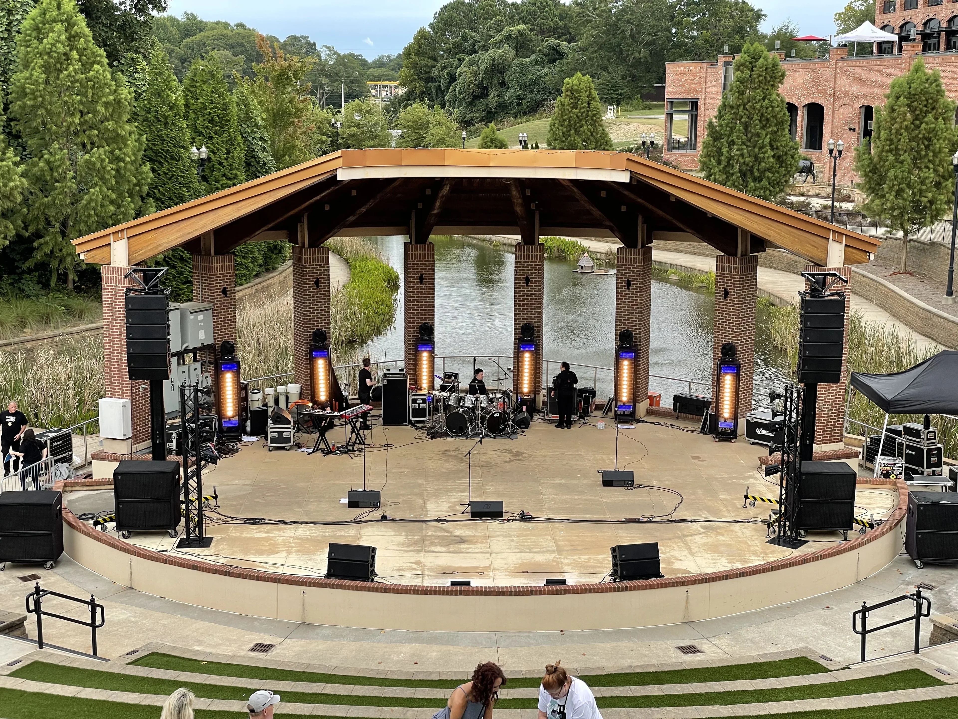Outdoor amphitheater concert with flown line array PA and crowd in Atlanta
