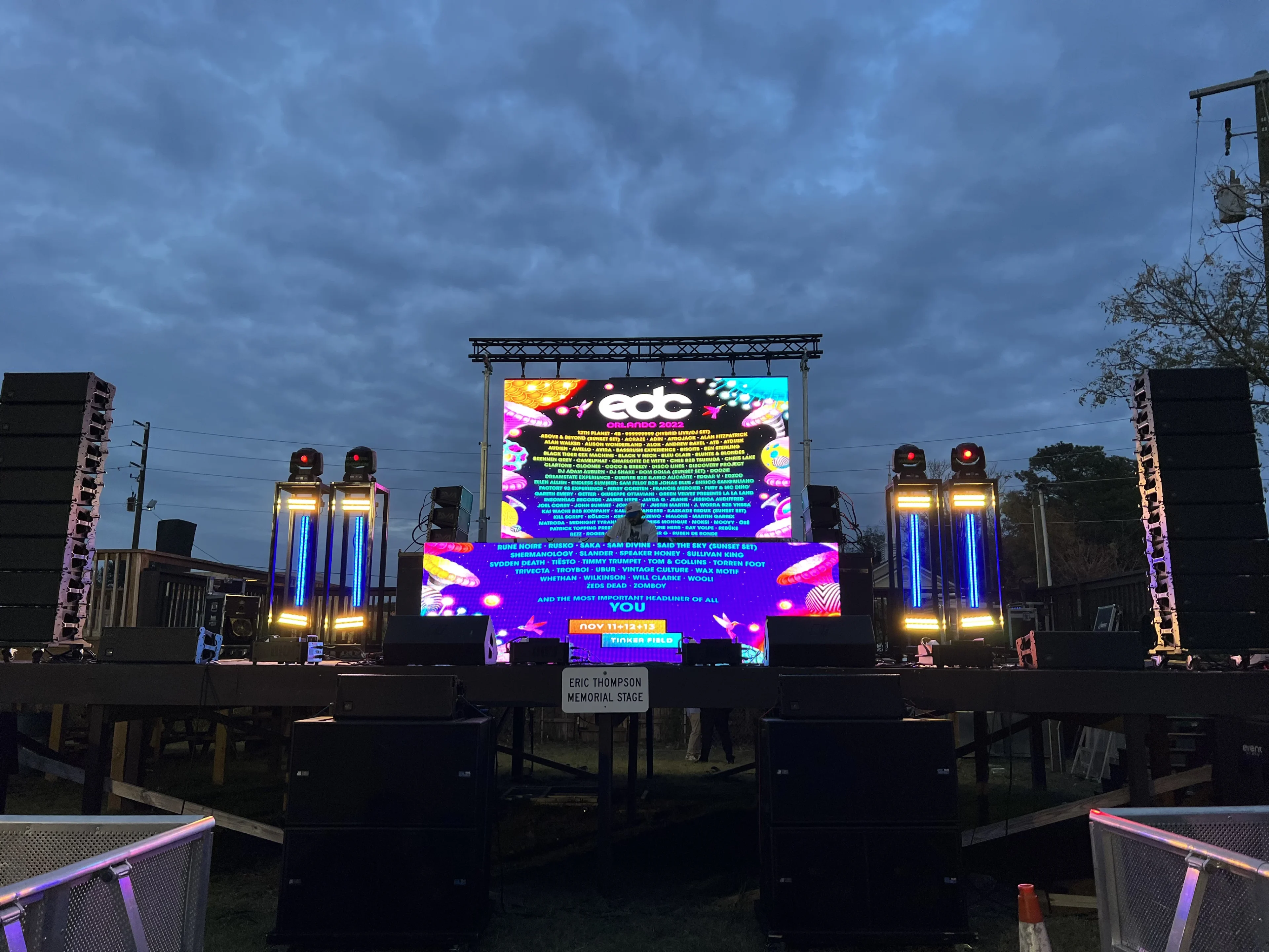 Evening outdoor stage with large LED video wall and moving head lighting towers ready for a Greek week concert