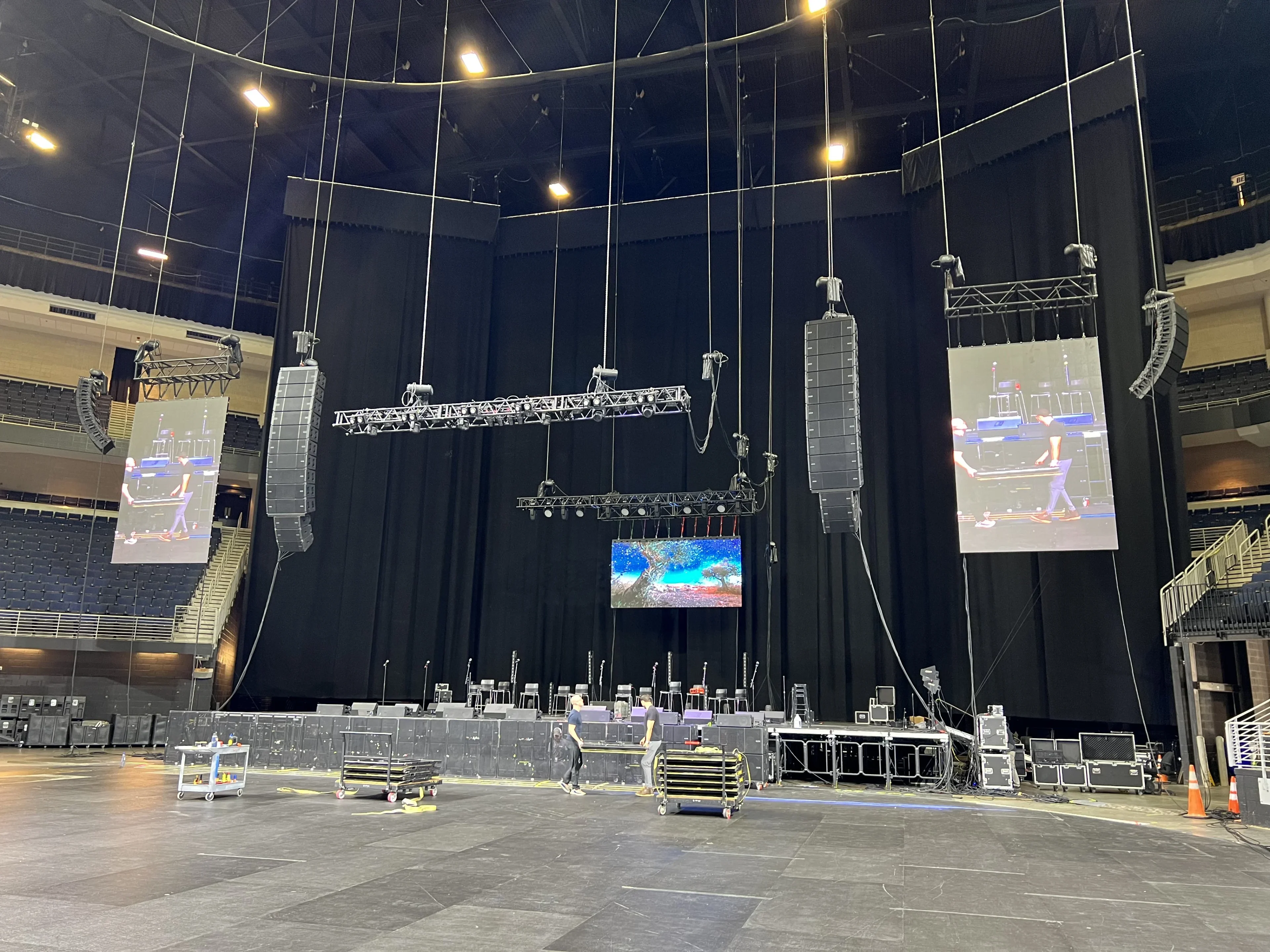 Arena concert with full stage production, lighting, and LED video walls