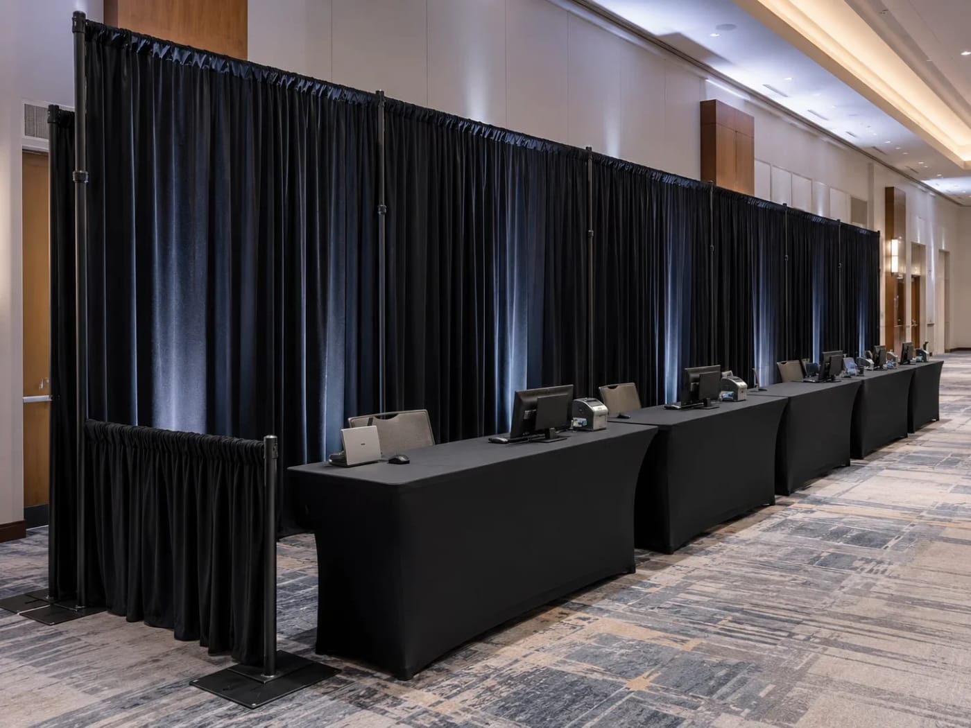 Long black draped backdrop wall behind a head-table row in an Atlanta ballroom.