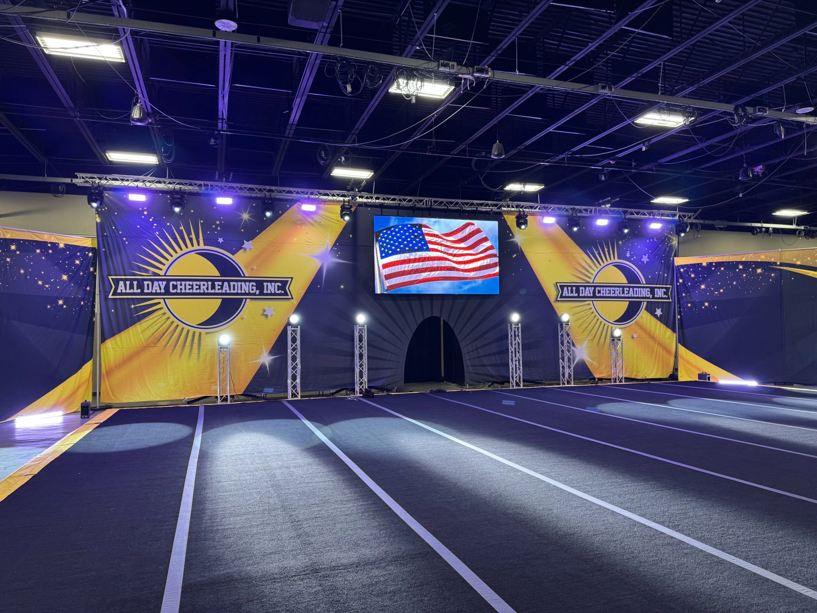 Cheerleading competition stage view with lighting rig and video wall
