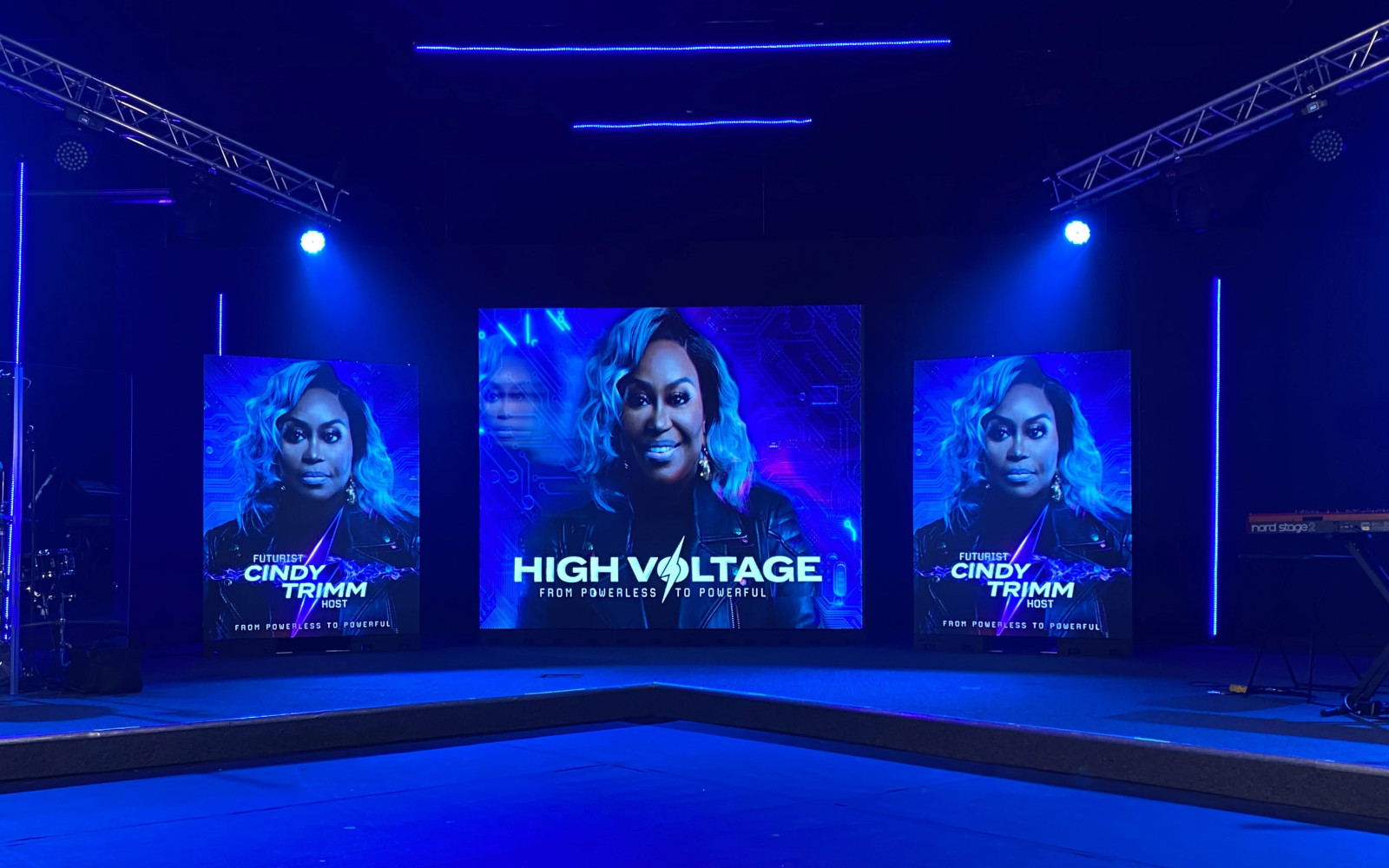 Event stage with electric blue wash lighting and truss-mounted spotlights
