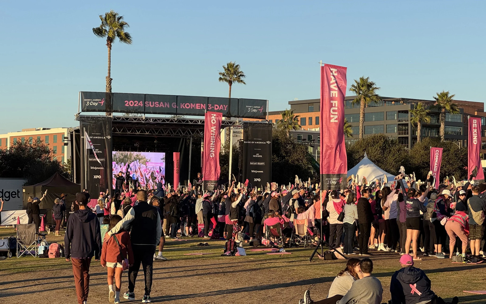 2024 Susan G. Komen 3-Day stage with LED video wall and large crowd on grass field