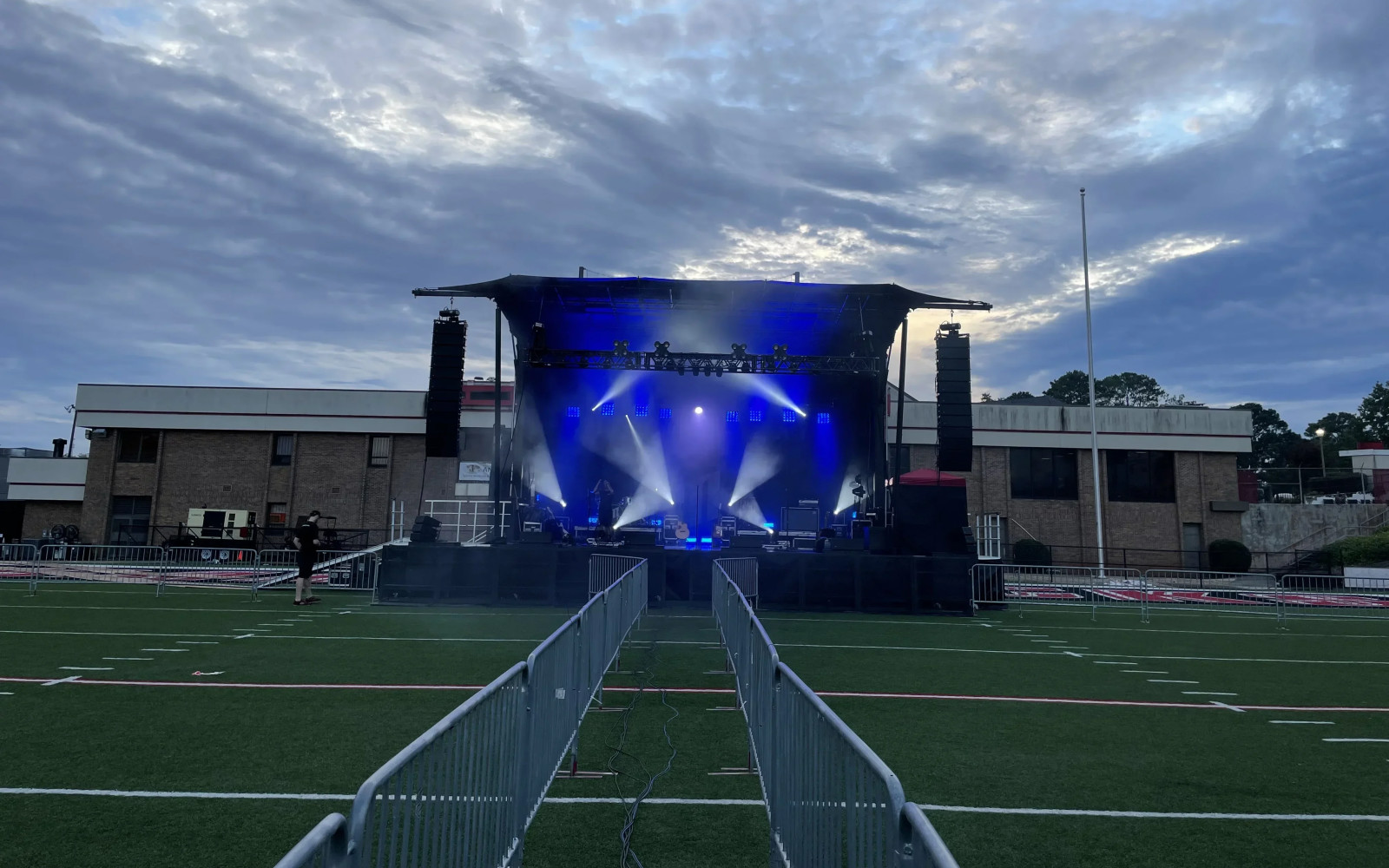 Outdoor campus concert at dusk with blue wash lighting and moving heads blazing through the SL260 stage rig on athletic field
