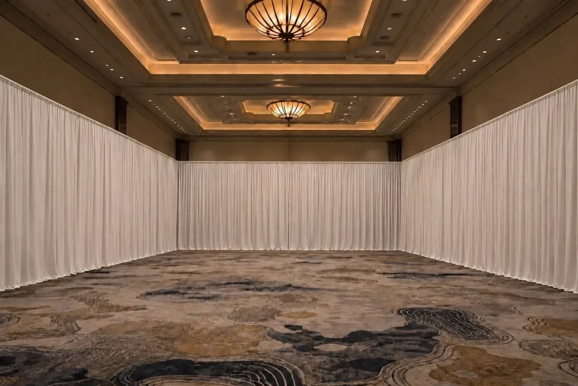 Full-height pipe and drape walls lining and dividing an empty Atlanta ballroom