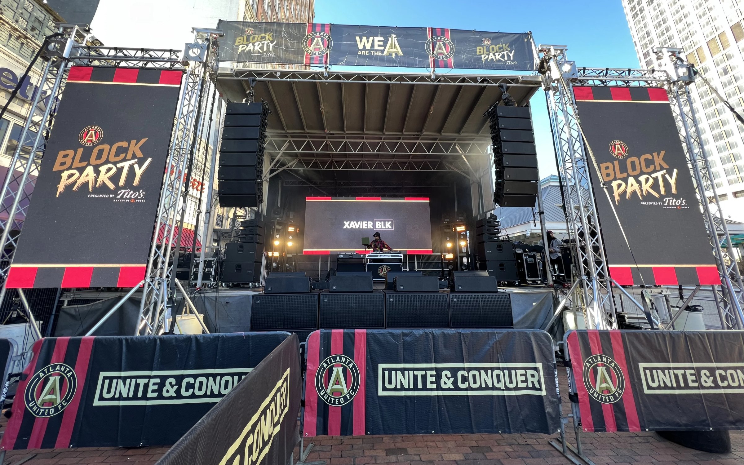 Outdoor festival stage with LED wall and branded truss towers at block party event
