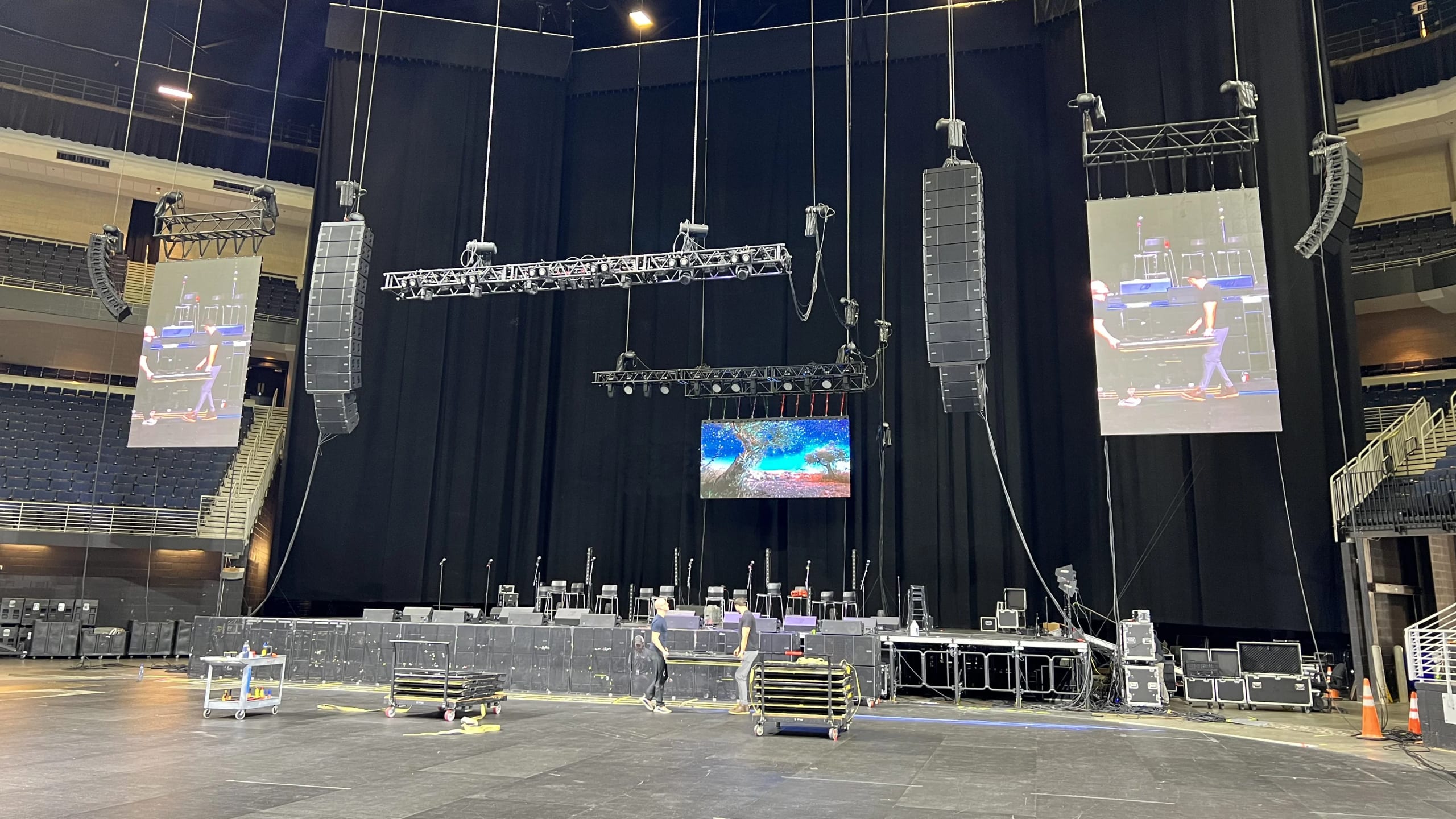 Arena concert production with flown line array PA, LED video walls, and intelligent lighting