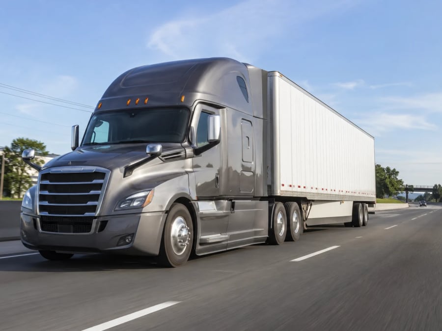 A tractor-trailer travelling a highway between a supplier and a jobsite